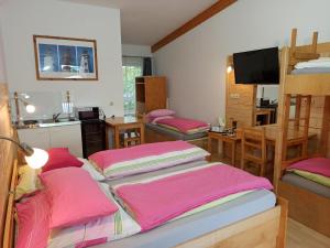 Habitación con 3 literas y sábanas rosas. en Max Motel, en Hinterzhof