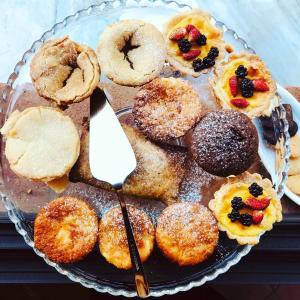 um prato de donuts num prato de vidro com uma espátula em B&b L' Orangerie em Pietrasanta