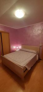 a bedroom with a bed with a pink wall at Hotel Ristorante Cibarium in Gualdo Tadino