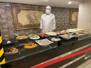 a man standing in front of a counter filled with plates of food at Akgun Hotel Beyazit in Istanbul