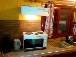 a microwave sitting on top of a kitchen counter at Sunrise Apartments in Palekastron