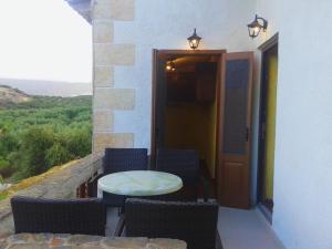 eine Terrasse mit einem Tisch und Stühlen auf dem Balkon in der Unterkunft Sunrise Apartments in Palekastro