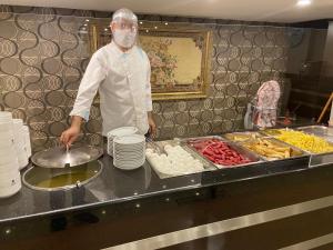 a chef standing in a kitchen preparing food at Akgun Hotel Beyazit in Istanbul