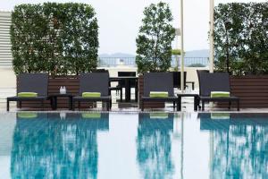 uma piscina com duas cadeiras e uma mesa e uma mesa em Centara Riverside Hotel Chiang Mai em Chiang Mai