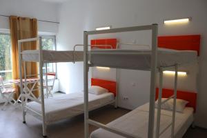 a room with three bunk beds and a window at Hi Espinho - Pousada de Juventude in Espinho