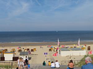 un grupo de personas de pie en una playa en De Linden, en Egmond aan Zee