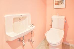 a pink bathroom with a toilet and a sink at Hotel Seagull Tenpozan Osaka in Osaka