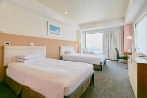 a hotel room with two beds and a desk at Hotel Seagull Tenpozan Osaka in Osaka