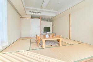 a room with a wooden table and a television at Hotel Seagull Tenpozan Osaka in Osaka