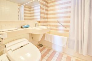 a white bathroom with a toilet and a sink at Hotel Seagull Tenpozan Osaka in Osaka