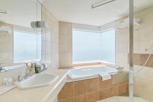 a bathroom with a tub and a sink and a window at Hotel Seagull Tenpozan Osaka in Osaka +37 photos