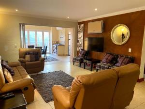 a living room with two couches and a television at Sands Beach Simbithi Eco Estate Luxury Villa in Ballito
