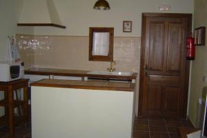 cocina con fregadero y puerta de madera en APARTAMENTO LAS ERAS en Hontanares