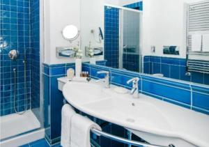 baño de azulejos azules con 2 lavabos y bañera en La Medusa Hotel - Dimora di Charme en Castellammare di Stabia
