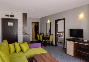 MPM Hotel Guinness في بانسكو: غرفة معيشة مع أريكة وغرفة طعام