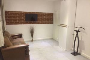 Una sala de estar con un sofá y un televisor en una pared. en Elegantes Haus im Dresdner Süden, en Bannewitz