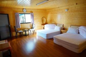 una stanza con due letti, un tavolo e una finestra di Yun Hsiang Zhan Chalet a Hualing