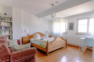 a bedroom with a bed and a couch and a chair at Gästehaus Sonne in Zuchwil