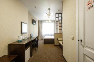 a hotel room with a desk and a bed at Inn Zolotaya Melnitsa in Belogorsk