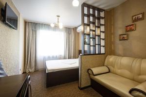 a room with a couch and a bed and a mirror at Inn Zolotaya Melnitsa in Belogorsk