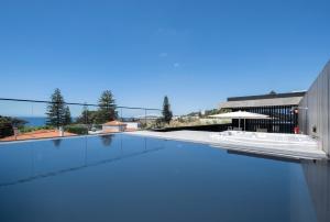 a swimming pool with blue water on top of a building at Aqua - Pópulo Eco Village in Ponta Delgada