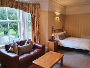 a living room with a bed and a couch at Strathmore Guest House in Keswick