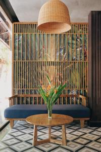 a room with a couch and a table with a plant at Seava Ho Tram Beach Resort in Ho Coc