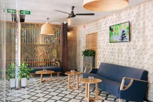 a lobby with a blue couch and two tables at Seava Ho Tram Beach Resort in Ho Coc