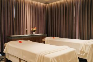 two beds in a room with curtains at Seava Ho Tram Beach Resort in Ho Coc