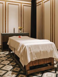 a bed with a white blanket on it in a room at Seava Ho Tram Beach Resort in Ho Coc