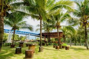 a park with palm trees and a roller coaster at Seava Ho Tram Beach Resort in Ho Coc