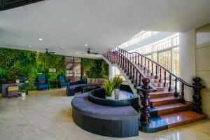 a lobby with a staircase and a seating area at Seava Ho Tram Beach Resort in Ho Coc