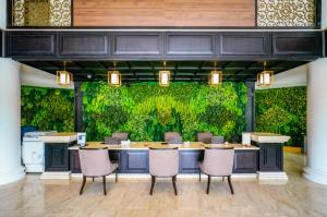 a conference room with a green wall with a table and chairs at Seava Ho Tram Beach Resort in Ho Coc