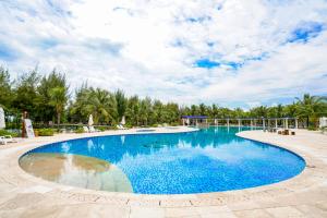 a swimming pool in a resort with trees in the background at Seava Ho Tram Beach Resort in Ho Coc