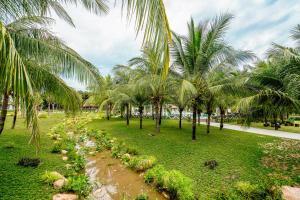 a row of palm trees in a park at Seava Ho Tram Beach Resort in Ho Coc