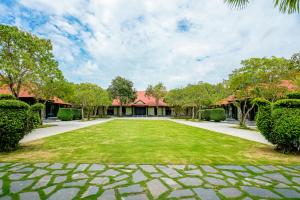an open courtyard with a lawn in front of a house at Seava Ho Tram Beach Resort in Ho Coc