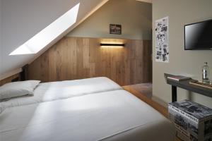a bedroom with two beds and a tv at Café Coureur Borgloon in Borgloon