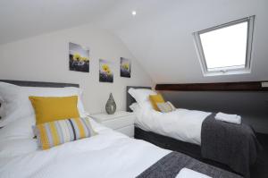 a bedroom with two beds and a window at Bishops Court Cottage in York