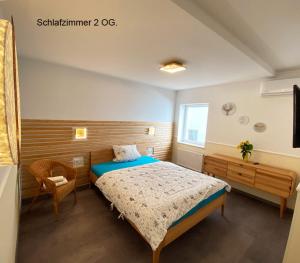 a bedroom with a bed and a chair and a window at Ferienhaus Berlin in Berlin