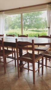 einen Holztisch und Stühle in einem Zimmer mit Fenster in der Unterkunft La Ferme de la Maugerie in Thoury
