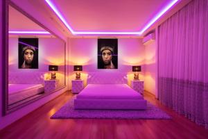 Fioletowa sypialnia z 2 łóżkami i lustrem w obiekcie Premium Jacuzzi Apartment w Kłajpedzie