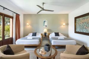 a hotel room with three beds and a couch at Hotel Punta Sur in Tarifa