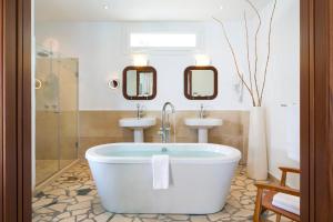 a bathroom with a bath tub and a sink at Hotel Punta Sur in Tarifa