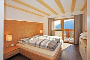 a bedroom with a bed and a large window at Außerflarerhof in Schenna