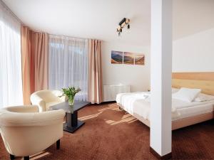 pokój hotelowy z dwoma łóżkami i krzesłem w obiekcie Hotel Łaziska w mieście Czchów +37 zdjęć