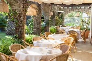 an outdoor restaurant with white tables and chairs at Hotel Punta Sur in Tarifa