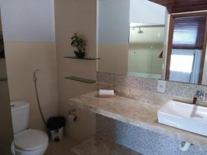 a bathroom with a sink and a toilet and a mirror at Pousada Innova in Natal