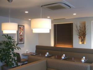 a dining room with tables and chairs and lights at Sotetsu Fresa Inn Higashi Shinjuku in Tokyo