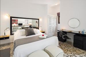 a bedroom with a large white bed and a desk at Hotel Punta Sur in Tarifa