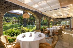 a restaurant with white tables and chairs on a patio at Hotel Punta Sur in Tarifa